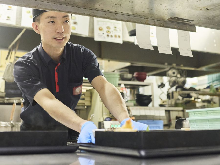 調理した料理を提供するE.S.さん