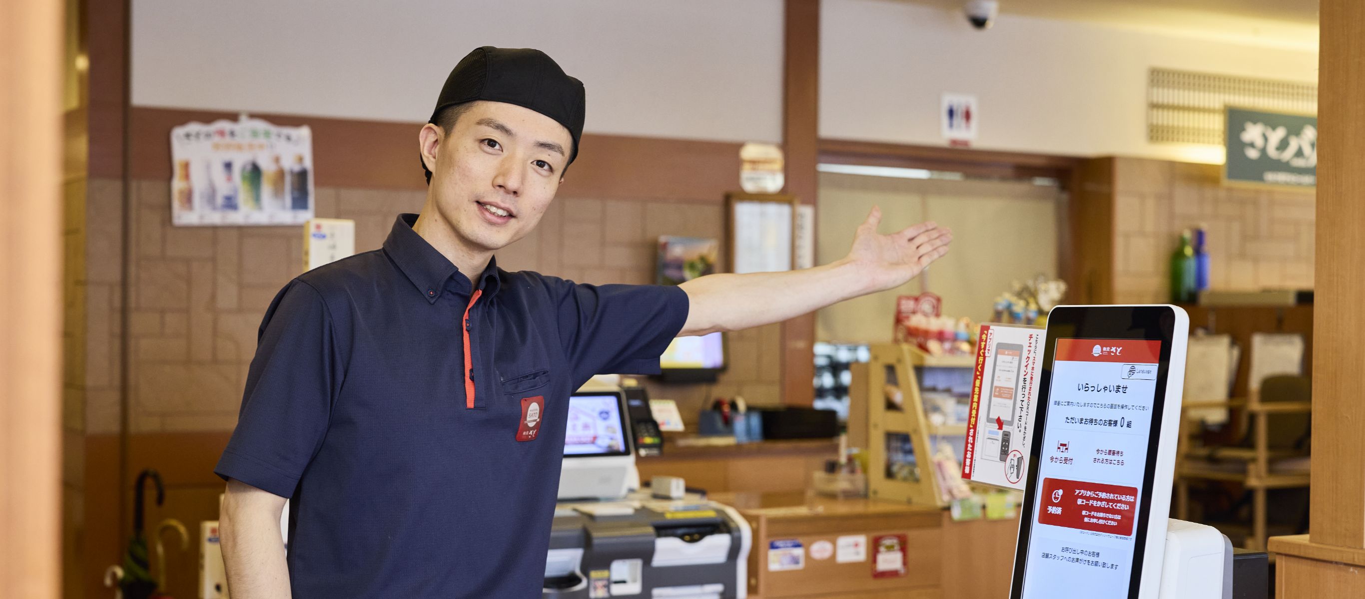 お客さまをお席へご案内する和食さと店長